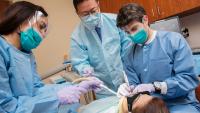 resident performing implant surgery